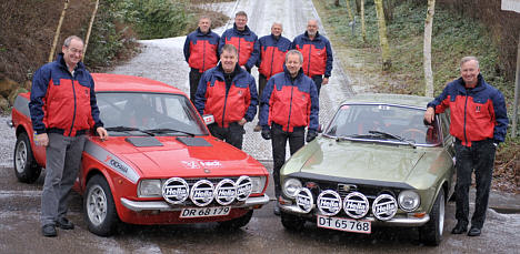 Scuderia Italia er godt rustet til Rallye-Monte Carlo Historique. Fra venstre ses codriver Arne Pagh, rallykører Lars Bækkelund, codriver Jens Gandrup, rallykører Bent Mikkelsen, og bagved står teamets mekanikere Per Troelsen, Oluf Albertsen, Arne Juel og Gert Udengaard.